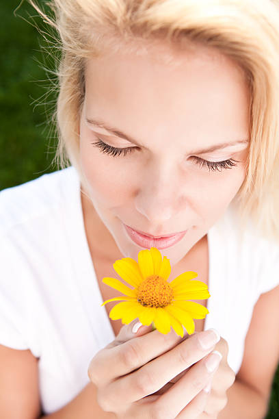 istock Young woman smelling yellow daisy 137058344
