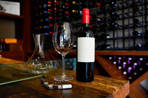 istock Red wine bottle, wine glass and corkscrew on rustic wooden table in a charming restaurant cellar. 1370584083