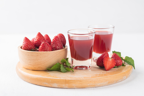 Strawberry juice in glass with fresh strawberry fruit on wooden board with white background, Healthy drink