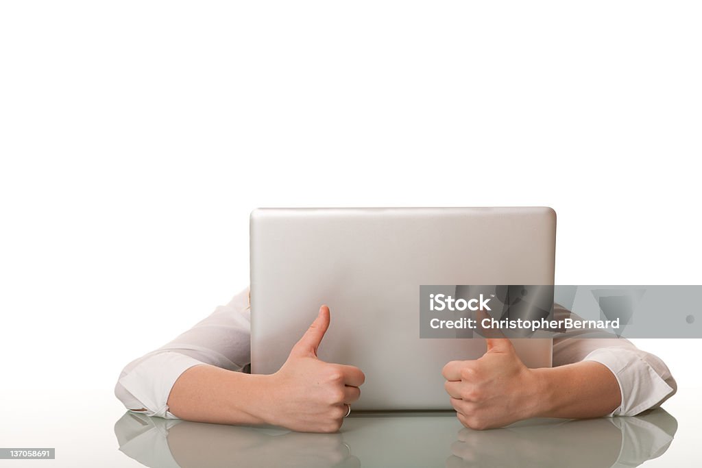 Businesswoman hiding behind her computer with thumbs up Shy Stock Photo