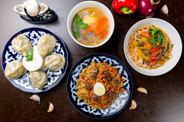 plats de la cuisine ouzbèke lagman, pilaf, shurpa avec bœuf et manti avec vue de dessus sur la table en bois - tatar photos et images de collection