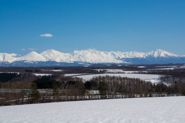 istock Upland field where snow remains and snowy mountains 1370588001
