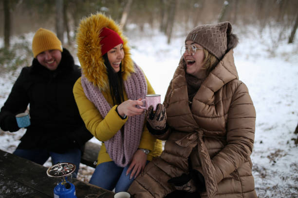 istock Frineds drinking hot drinks on snow stock photo 1370589039
