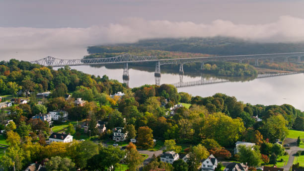 High Aerial Shot of Rip Van Winkle Bridge Aerial shot of Catskill, New York on a sunny day with rolling fog over the mountains. hudson river stock pictures, royalty-free photos & images
