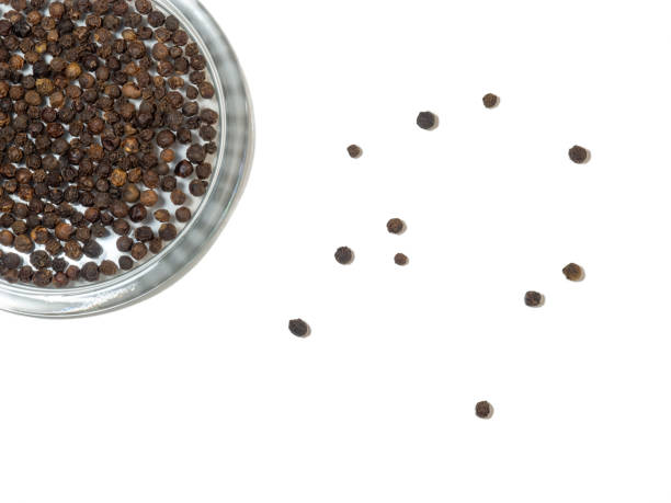 istock black peppercorns in a glass plate on a white background. 1370590263