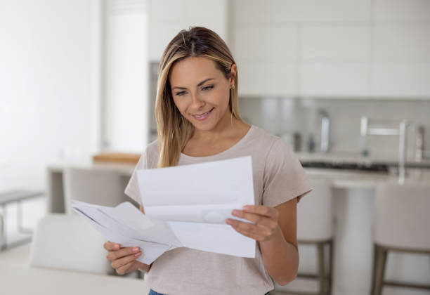 kobieta w domu czytająca list pocztą - opening mail zdjęcia i obrazy z banku zdjęć