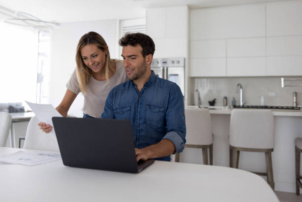 istock Loving couple at home paying bills online 1370591084