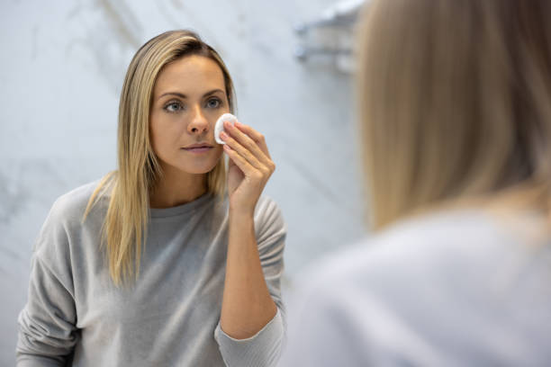 istock Woman in the bathroom cleansing her face using a botton pad 1370591169