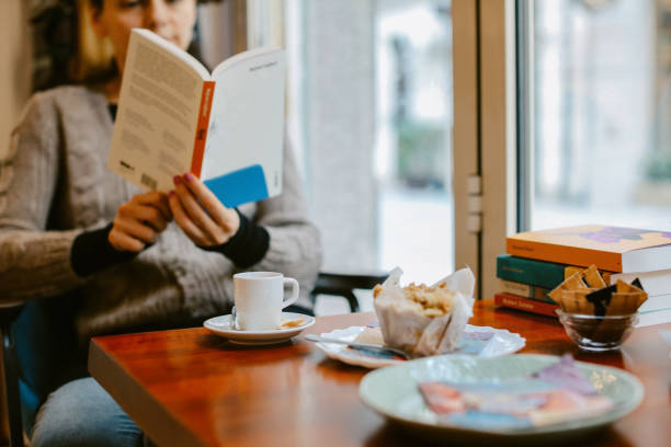 Two women sitting in the cafe, having a chat, coffee and sweets.