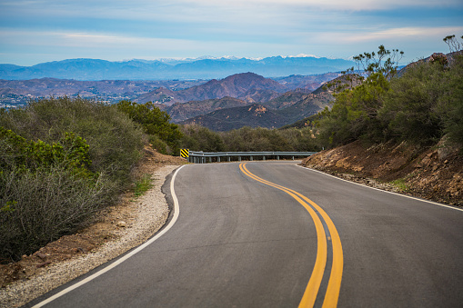 Scenic Santa Monica Mountains Road in Malibu California. Covered by Snow San Bernardino Mountains in a Distance. United States of America.