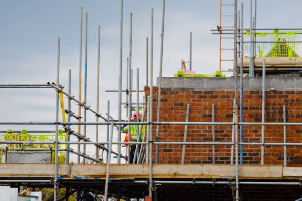 scaffolder erection scaffolds during new residential house construction - uk scaffolding construction building activity imagens e fotografias de stock