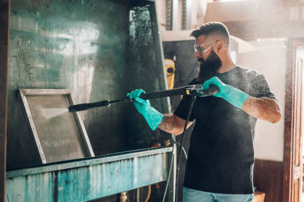 istock Male worker cleaning screen frame with water in a printing workshop 1370596747