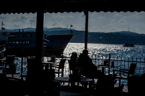 Two tourists as a passenger ferry crosses the Bosphorus\nhe is watching her.