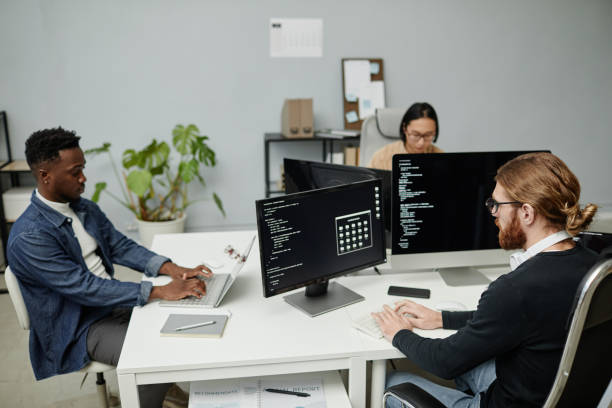 istock Group of young intercultural software engineers working in front of computer monitors 1370598608