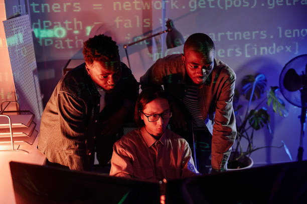 istock Group of young intercultural programmers bending in front of computer monitors 1370598626