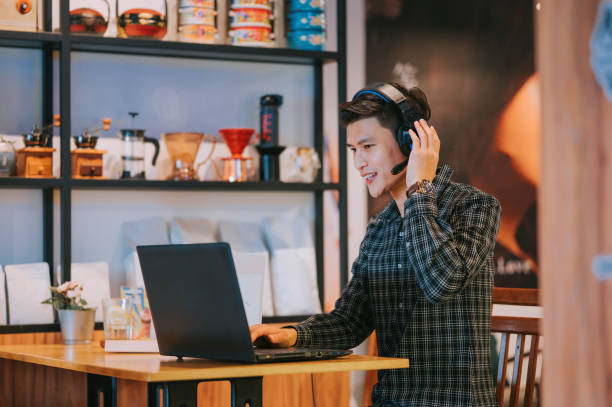 istock Asian Chinese man video call working with his laptop at cafe 1370601047