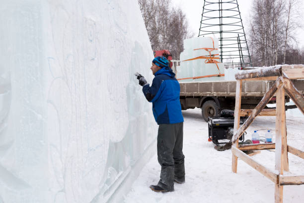 istock Sculptor in a blue winter suit with a chisel in his hands at work 1370605267
