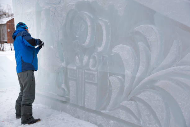 istock Sculptor in a blue winter suit with a chisel in his hands at work 1370605268