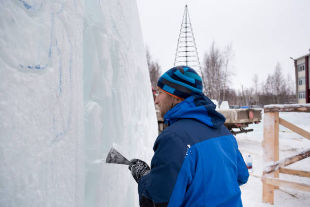 istock Sculptor in a blue winter suit with a chisel in his hands at work 1370605281
