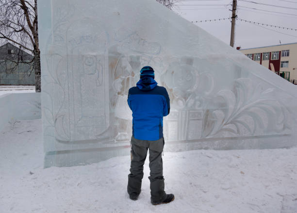 istock Sculptor in a blue winter suit with a chisel in his hands at work 1370605362