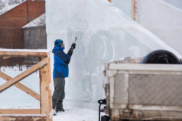 istock Sculptor in a blue winter suit with a chisel in his hands at work 1370605386