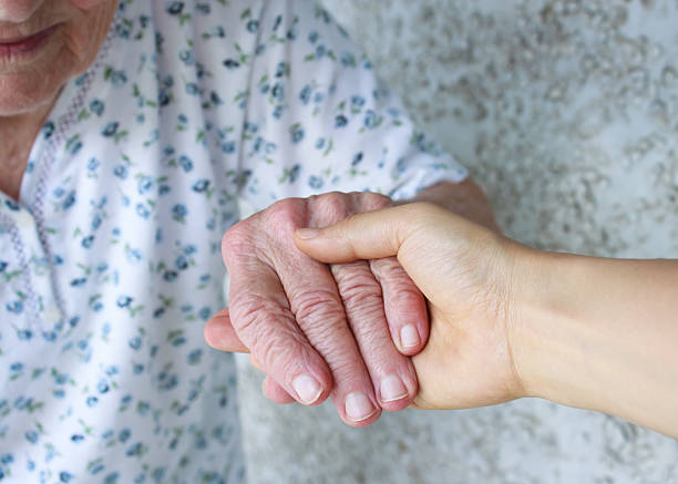 istock Caregiver holding seniors hand 137060656
