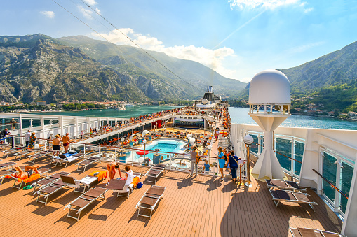 Crowded upper deck of the MSC Musica cruise ship as it pulls into the harbor of Kotor Montenegro on Boka or Bay of Kotor.