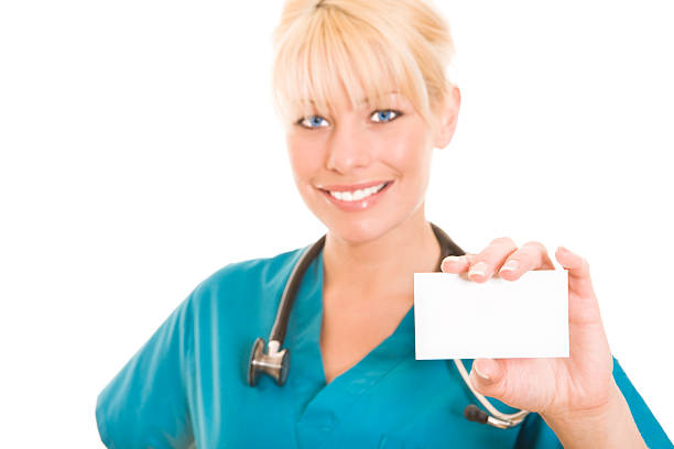 Smiling nurse holding a business card isolated on white background