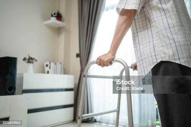 Close Up Hand Of Senior Disabled Man Walk With Walker At Nursing Home Asian Older Elderly Handicapped Male Patient Have Weak Leg Slowly Use Zimmer Frame To Support Medical Therapy Insurance Concept Stock Photo - Download Image Now