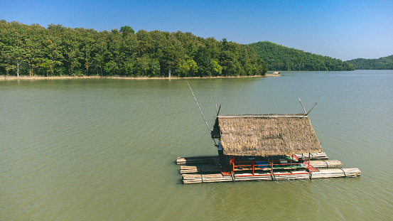 Loei Province, Thailand - December 2021 : Area of Huai Krathing reservoir with bamboo raft shelter for Rafting and Eating. Beautiful natural landscape of the river and mountain with blue sky