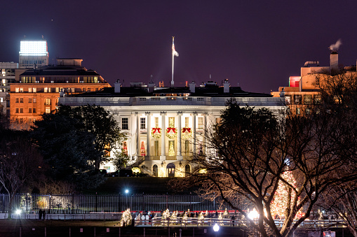 Washington DC, USA - December 20th, 2021: The Whitehouse at night with the Christmas Tree Illuminated