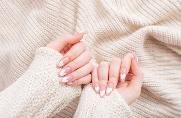 female hands with beautiful long nails with  manicure with  heart pattern in winter clothes female hands with beautiful long nails with  manicure with  heart pattern in winter clothes fall nail art stock pictures, royalty-free photos & images