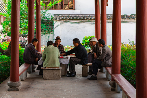 One autumn afternoon in September 2013, a group of elderly people happily played cards in a pavilion in a street park in the ancient city of Lijiang, Yunnan, China.