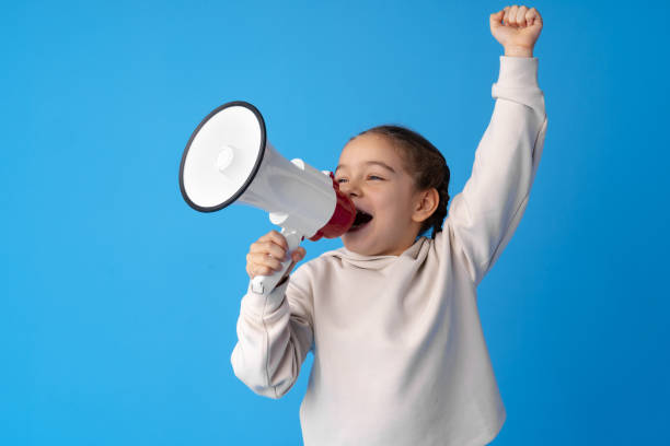 青い背景にメガホンを使用して子供の女の子 - marketing megaphone child using voice ストックフォトと画像