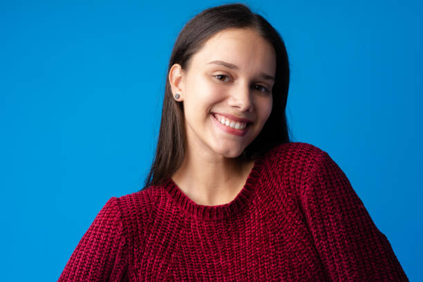 istock Pretty smiling girl portrait against blue background in studio 1370628734