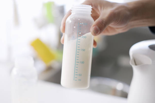 双子の赤ちゃんのためのミルクを作るアジアの男性 - feeding bottle ストックフォトと画像