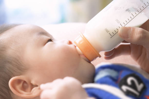 istock Asian baby drinking milk from a baby bottle 1370629810