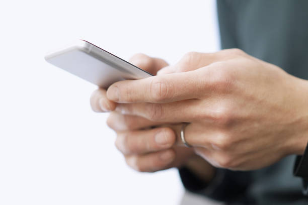 Asian man typing text on his smartphone stock photo
