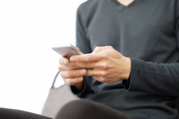 Asian man typing text on his smartphone
