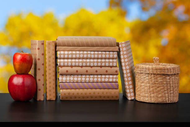 Stack of books on wooden table against blurred background, close up