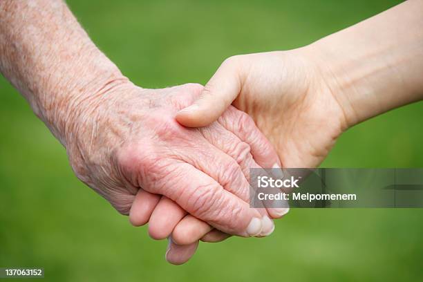 Joven Mujer Agarrando Antiguo Mano De Mujer Foto de stock y más banco de imágenes de Mujeres jóvenes - Mujeres jóvenes, Mujeres mayores, Agarrados de la mano