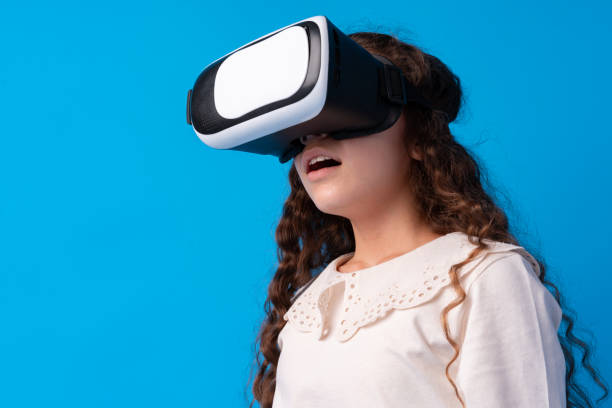 istock Girl with virtual reality glasses on blue background. 1370634351