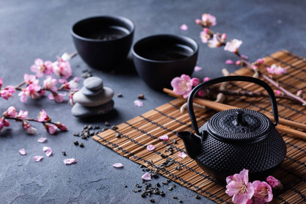istock Teapot and tea cups with blooming almond tree branches 1370635579