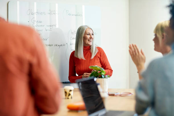 barcelona geschäftsfrau präsentiert ziele für das neue jahr - business meeting teamwork office happiness stock-fotos und bilder