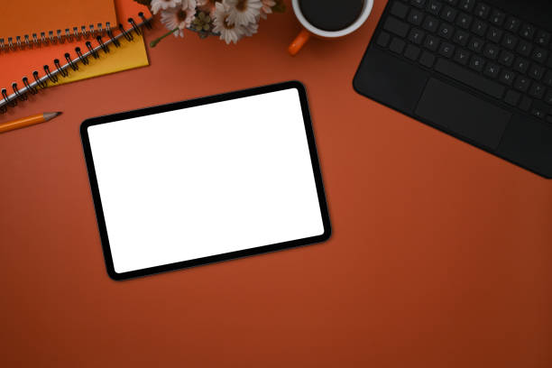 istock Flat lay mockup digital tablet, laptop, coffee cup and notebook on orange background. 1370642490