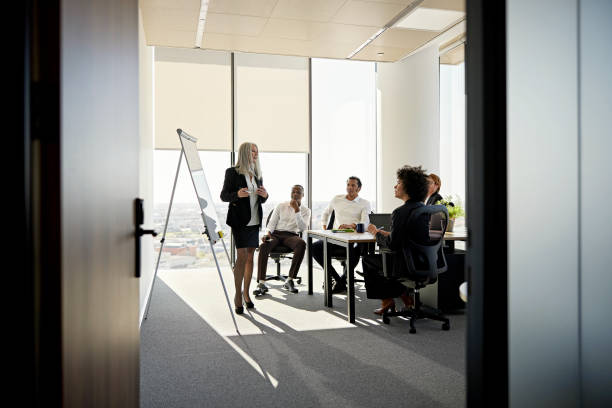 istock Project manager discussing plans with team in meeting room 1370642514
