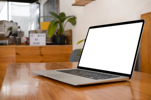 istock Computer laptop with white empty display on wooden table at coffee shop. 1370642612