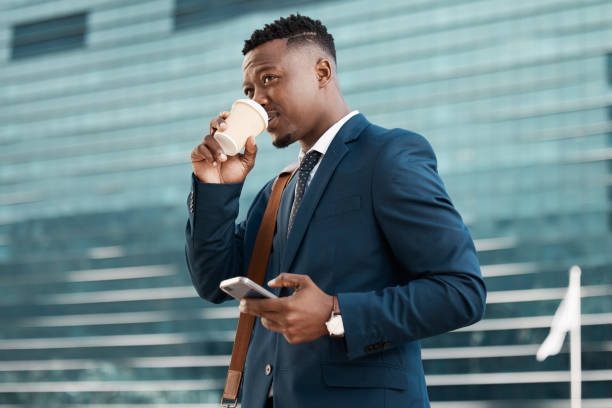 istock Shot of a young businessman drinking coffee while using his smartphone 1370644091