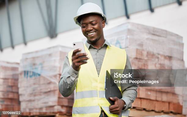 Shot Of A Young Businessman Using His Smartphone While On A Construction Site Stock Photo - Download Image Now