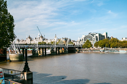 Charing Cross Train Station on Thames River in City of Westminster, London. An ice cream illustration is at the bottom left.